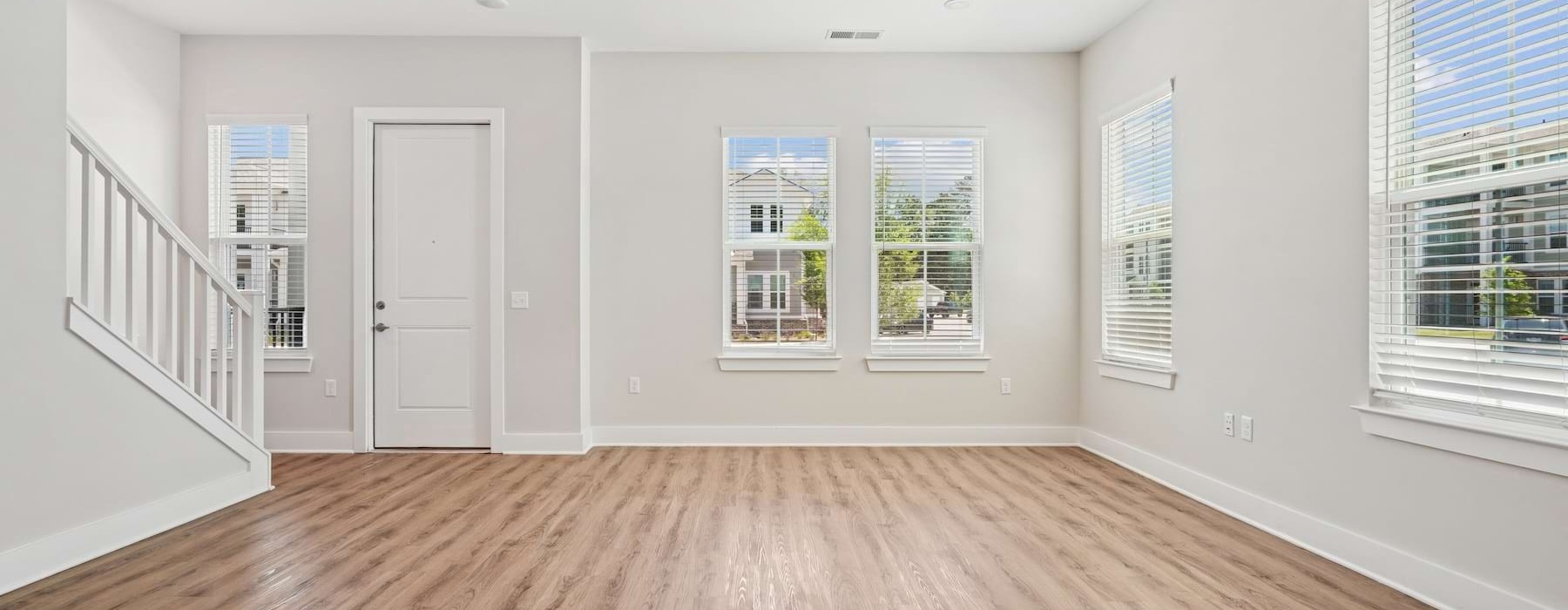 an empty living room with white walls and wood floors