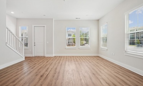 Wide open living areas perfect for entertaining an empty living room with white walls and wood floors